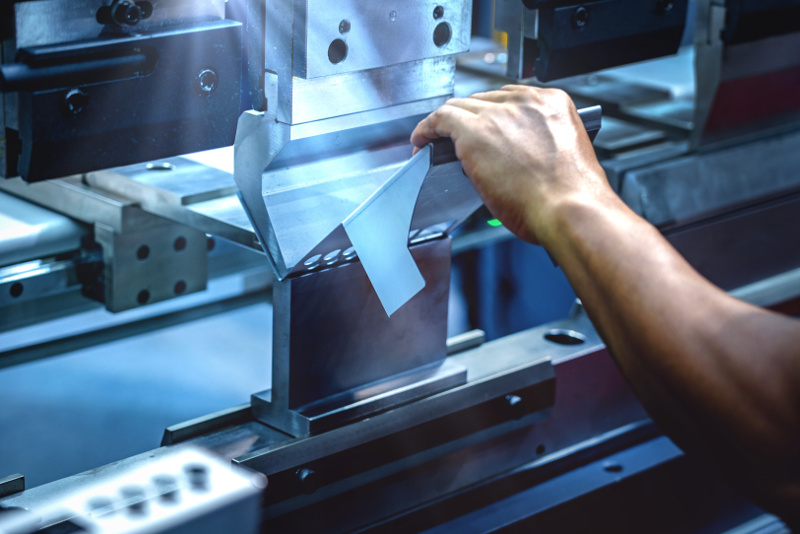 Workers bending sheet metal by CNC machines